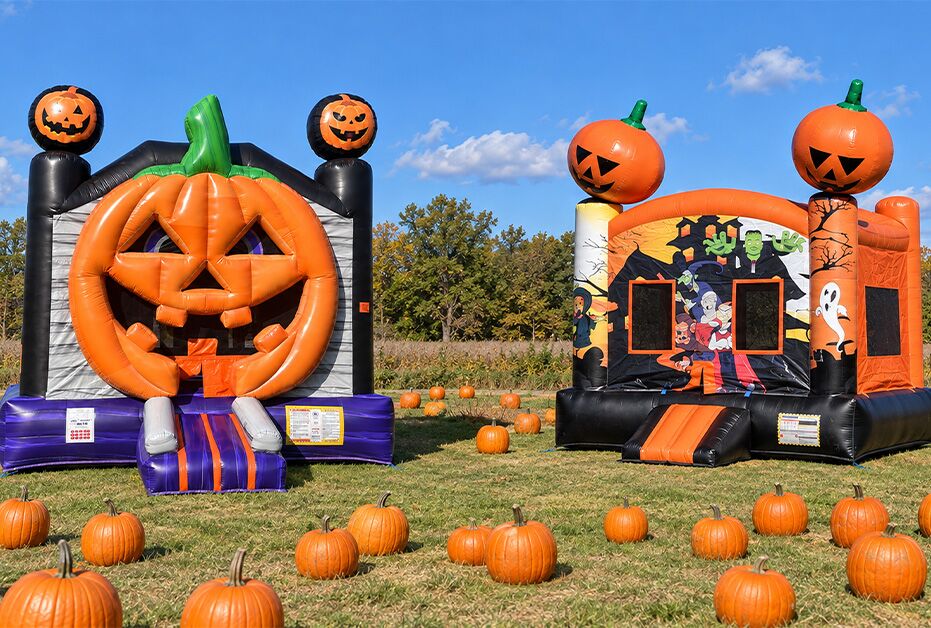 Jack the Bouncer, a jack-o'-lantern bounce house, beside the Halloween Bounce House in a pumpkin patch